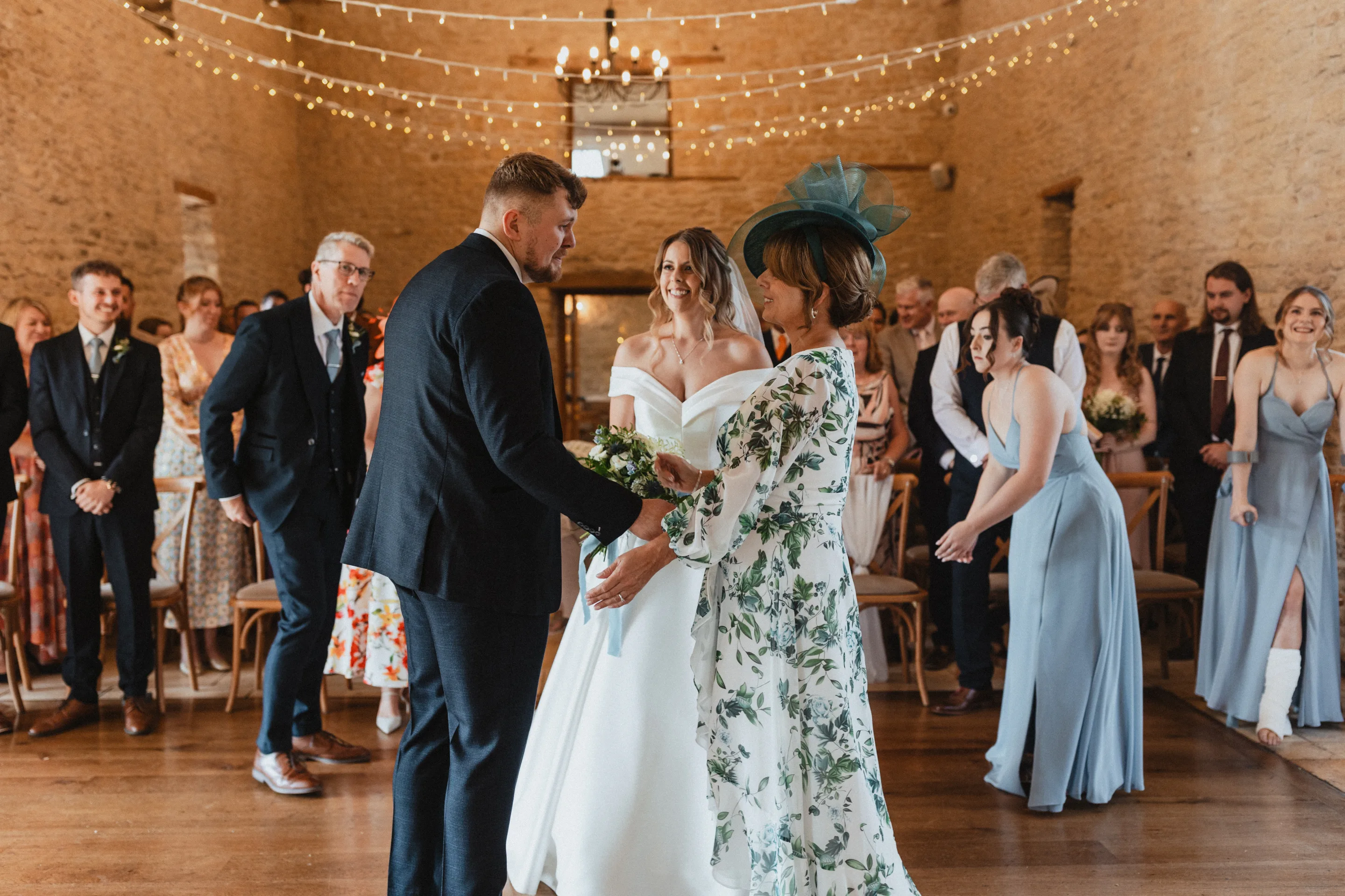 Indoor wedding ceremony at Kingscote Barn with natural light and wooden beams