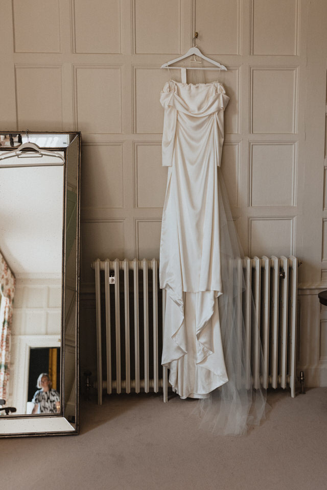 A bride's wedding dress hanging in the bridal suite at Elmore Court